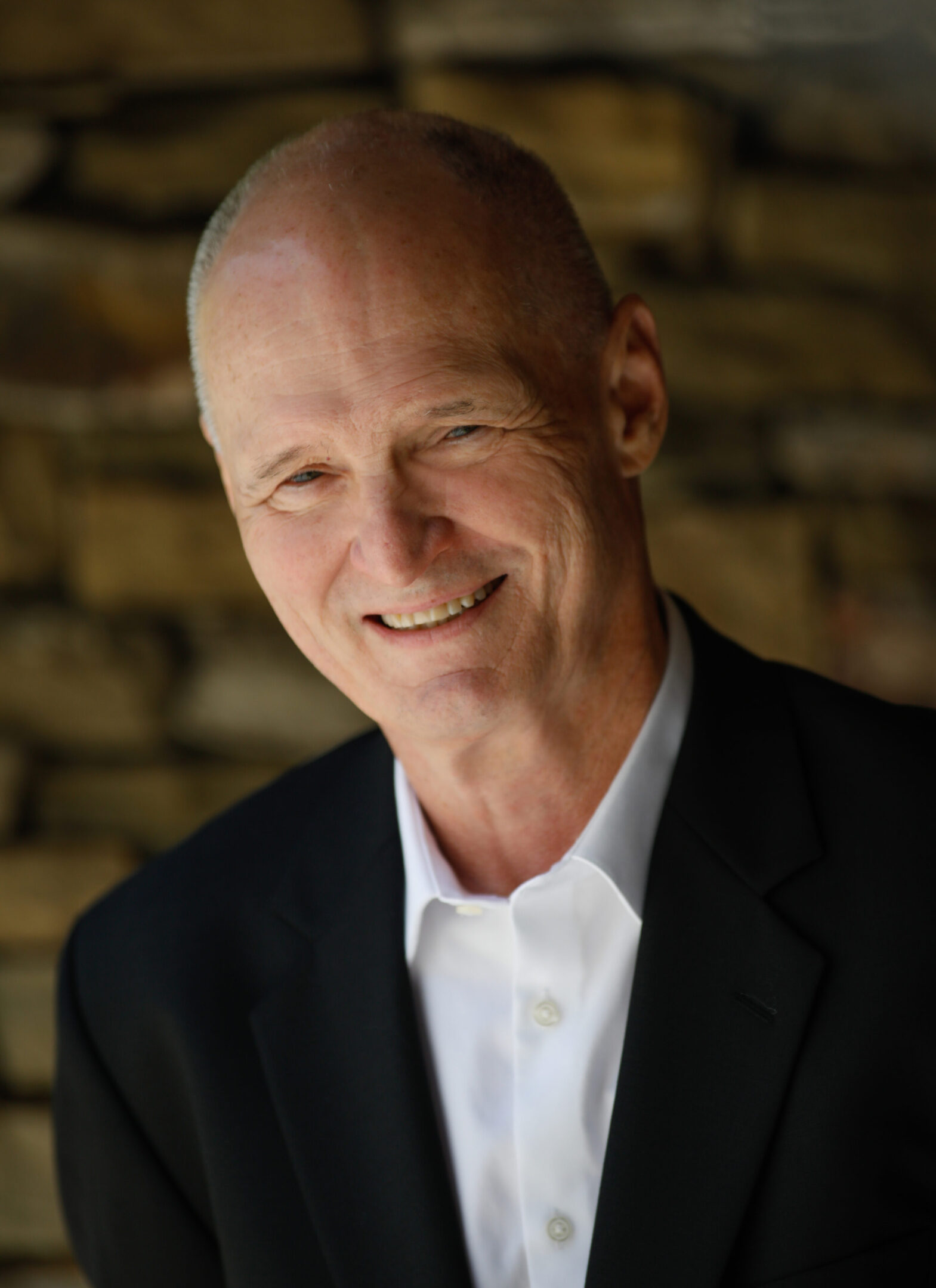 A man in a suit and tie smiling for the camera.